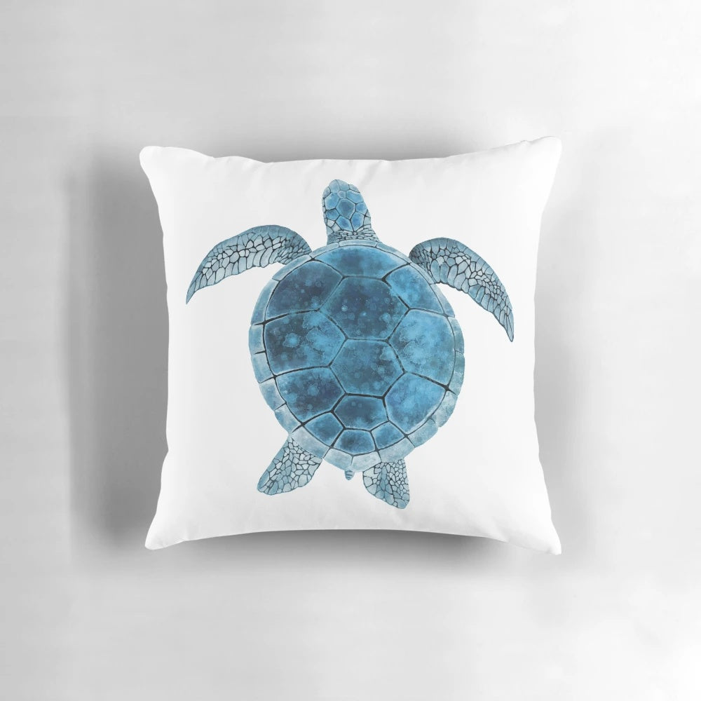 Closeup of a vibrant watercolor painting of a sea turtle in shades of turquoise and blue on a decorative throw pillow