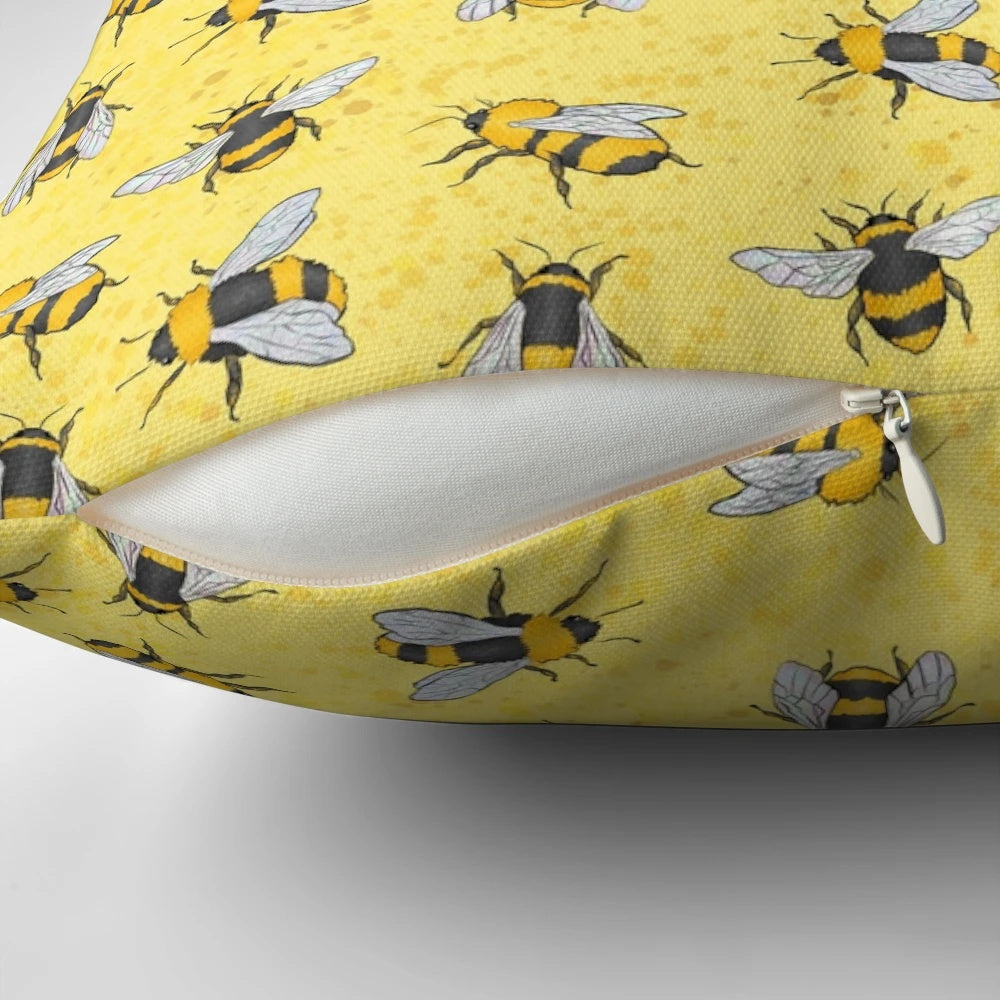 A yellow and black patterned pillow featuring a repeating bumble bee design