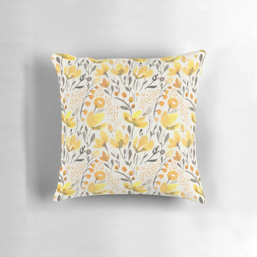Colorful watercolor-style yellow flowers and foliage on a throw pillow