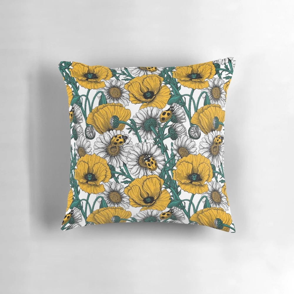 Close-up image of a decorative pillow featuring a vibrant yellow and white floral pattern inspired by a countryside meadow.