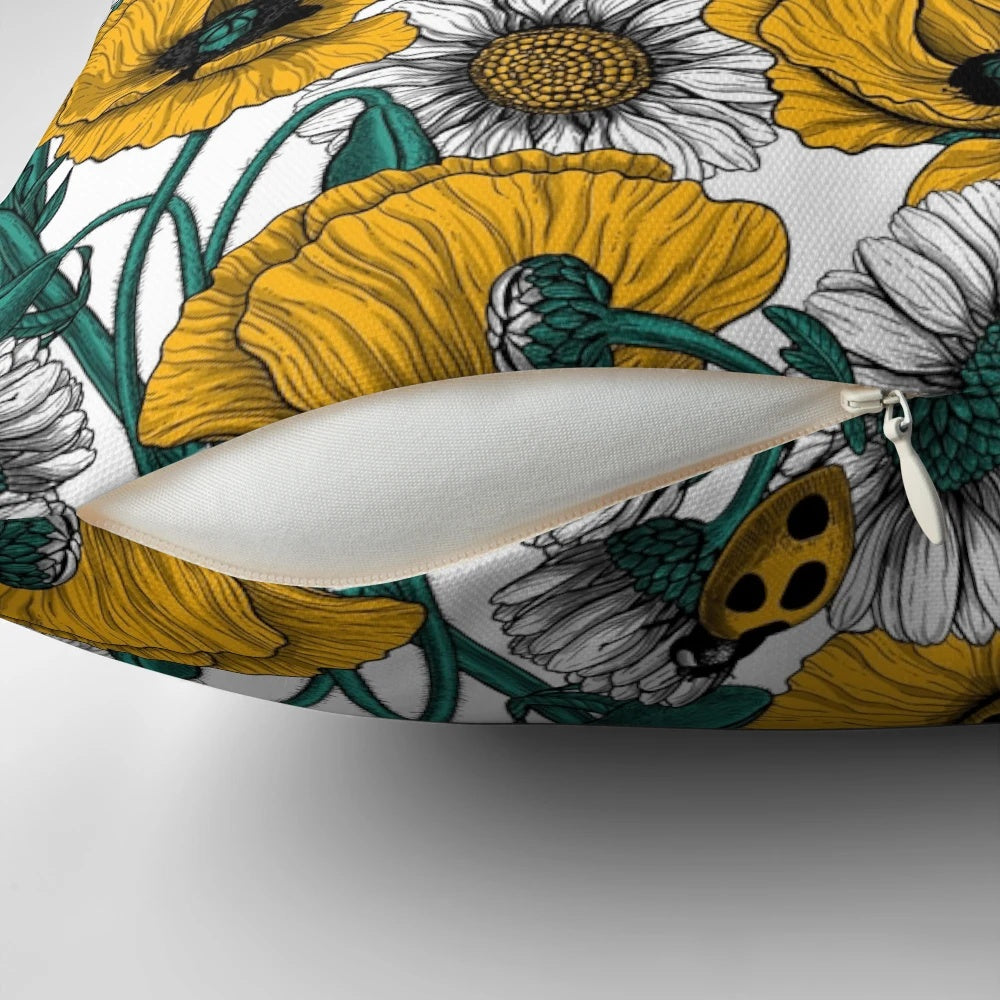 Close-up image of a decorative pillow featuring a vibrant yellow and white floral pattern inspired by a countryside meadow.