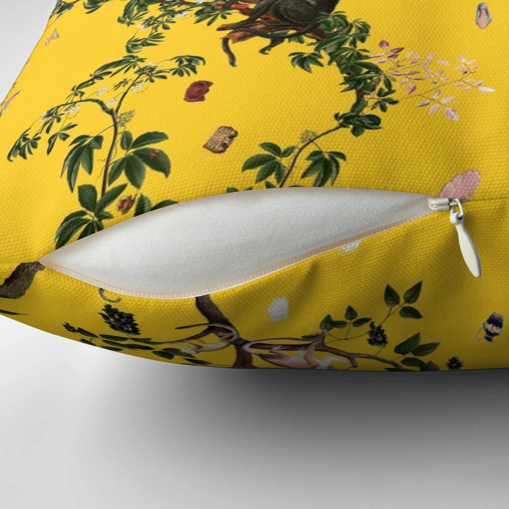 Closeup of a yellow pillow with a vibrant monkey and floral design, perfect for tropical-themed home decor.