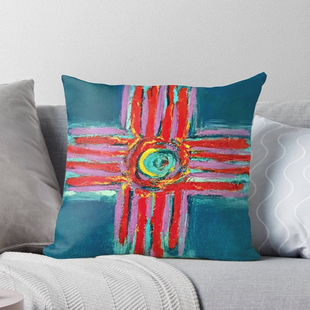 Decorative pillow featuring a textured zia symbol design in a blend of vibrant teal, lavender, and red colors.