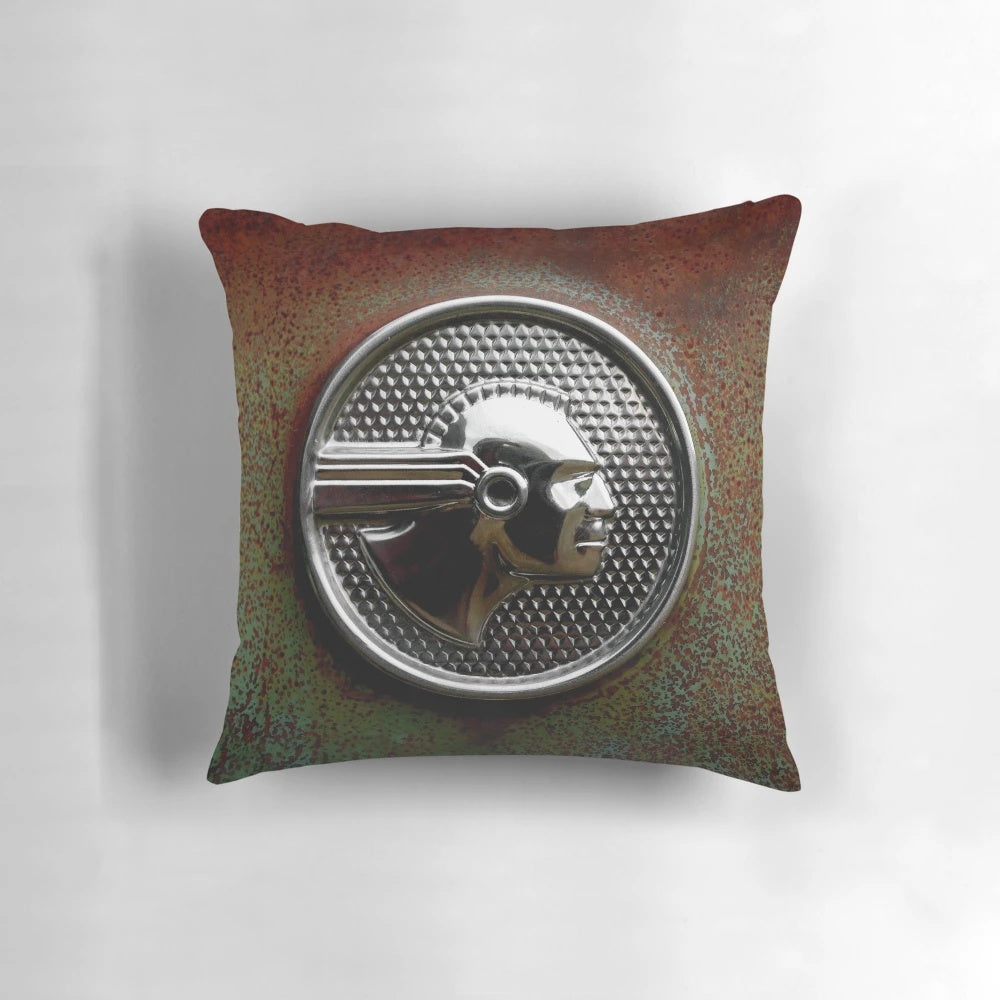 Vintage abandoned 1952 Pontiac Chieftain emblem pillow with rustic, patina-ed chrome and native american-inspired design