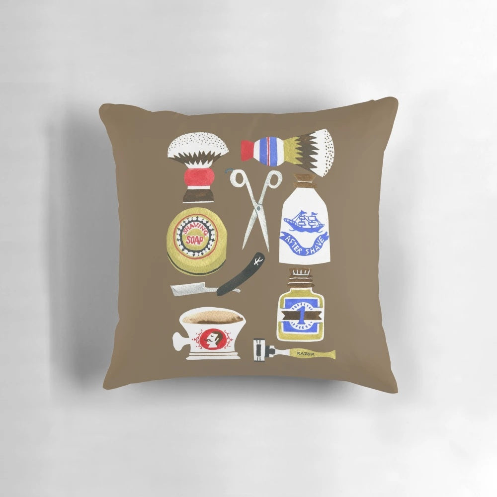 Decorative vintage-style pillow with a barber shop pattern, featuring shaving brushes, soaps, and other classic barber supplies.