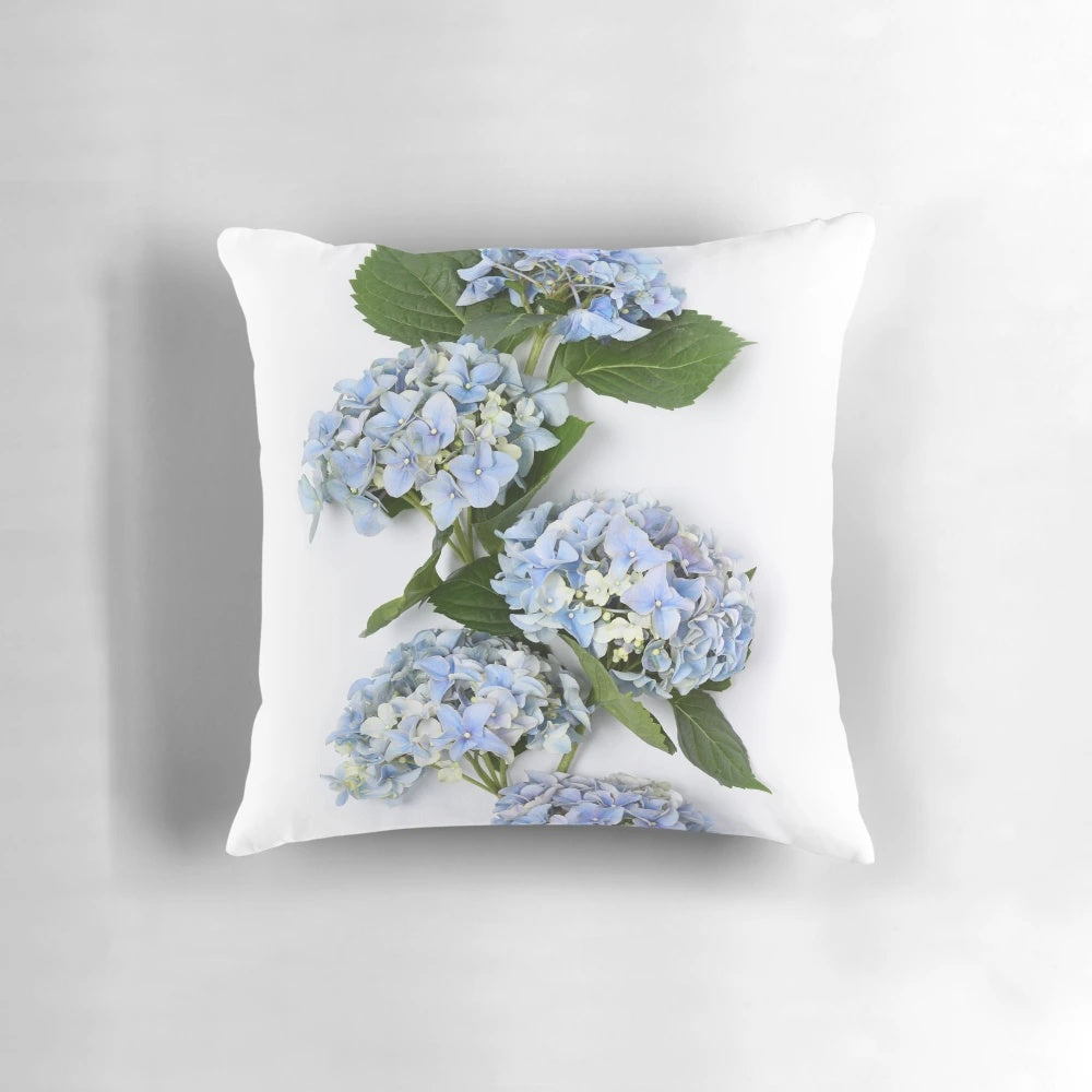A beautiful bouquet of blue hydrangea flowers on a decorative throw pillow