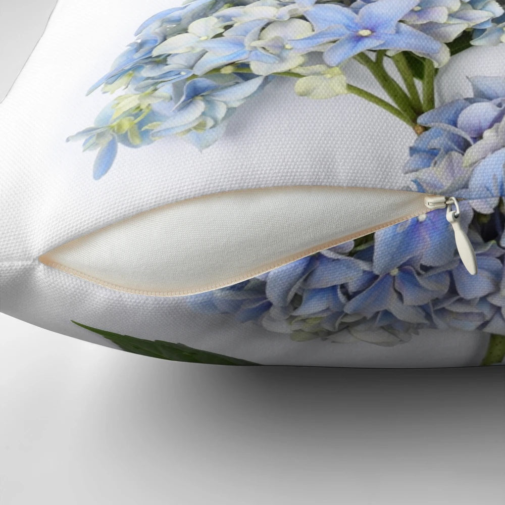 A beautiful bouquet of blue hydrangea flowers on a decorative throw pillow