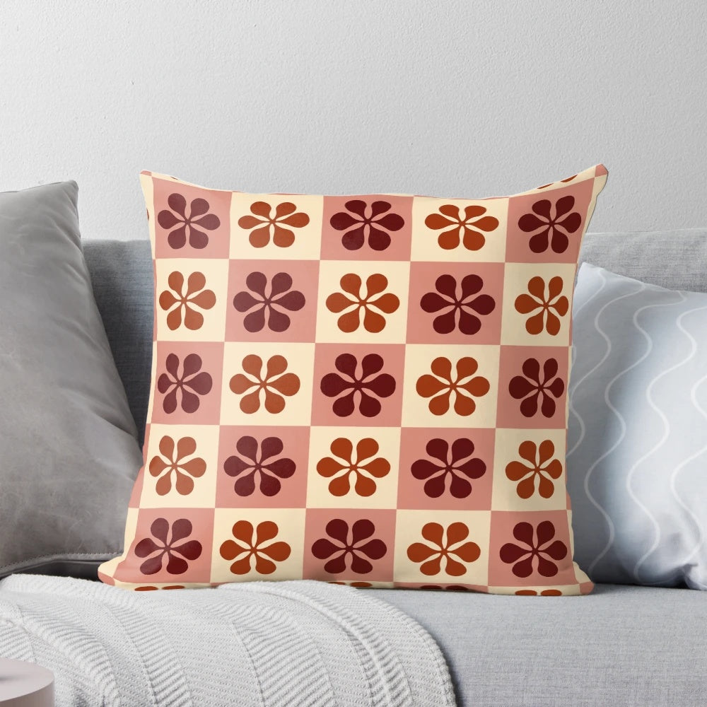 Burgundy and mauve checkerboard pattern pillow with a vintage floral design, perfect for adding a touch of retro style to any room.