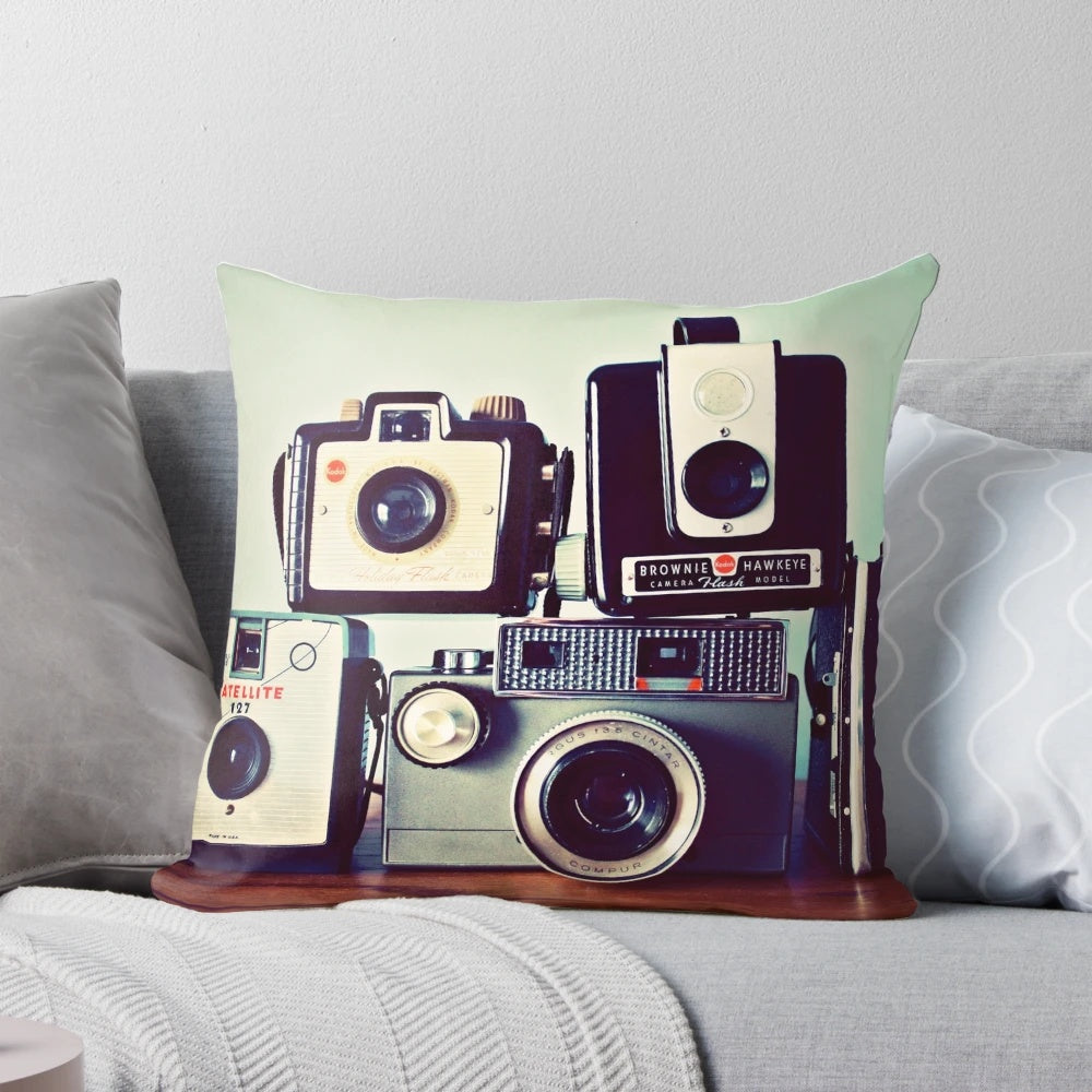Vintage camera-themed decorative pillow featuring a collage of retro film cameras and photography equipment