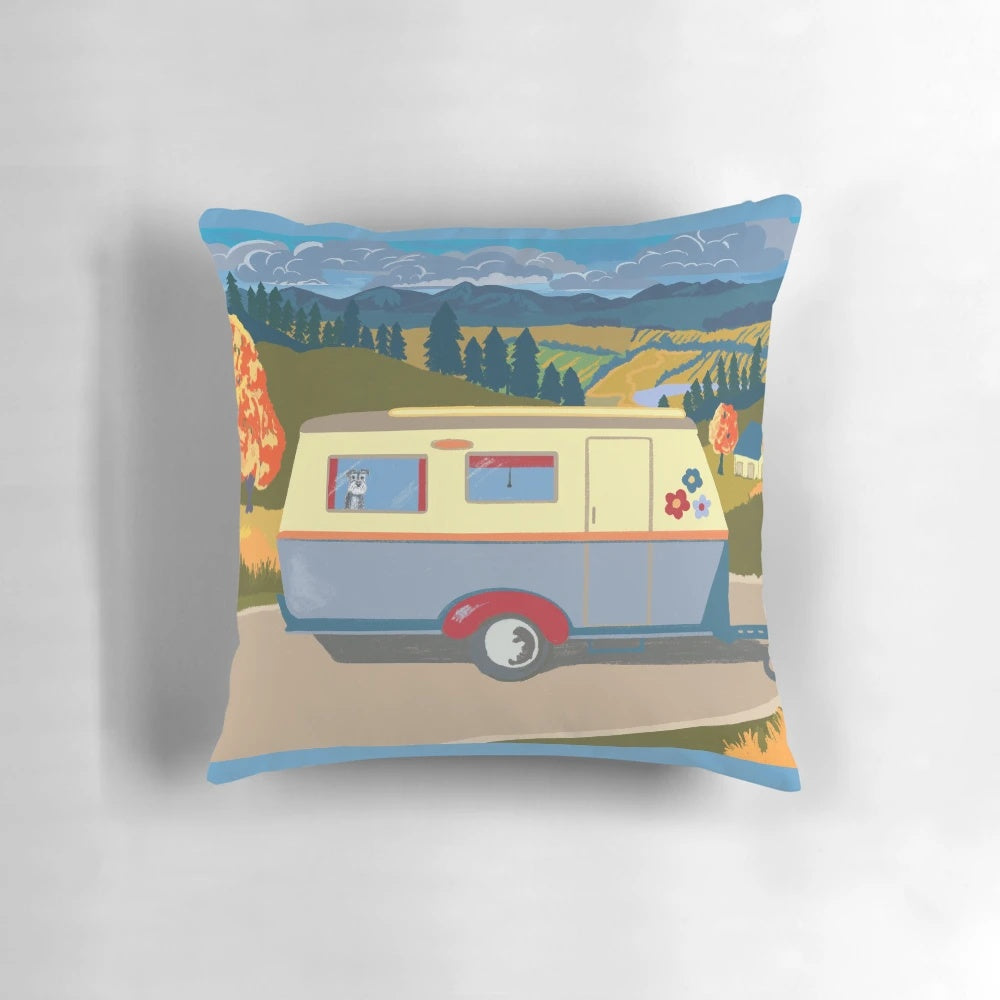A decorative pillow featuring a vintage-inspired caravan illustration with a schnauzer accent.