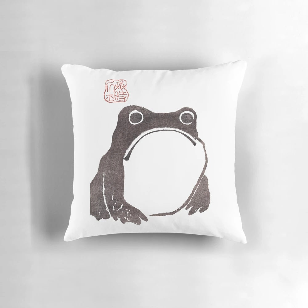 Vintage-style sketch of a grumpy frog on a decorative pillow
