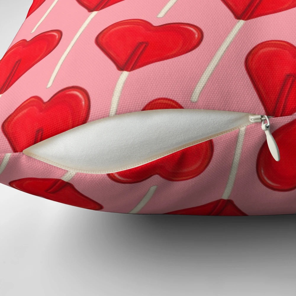 A pink, heart-shaped lollipop decorative pillow with a retro, vintage design.