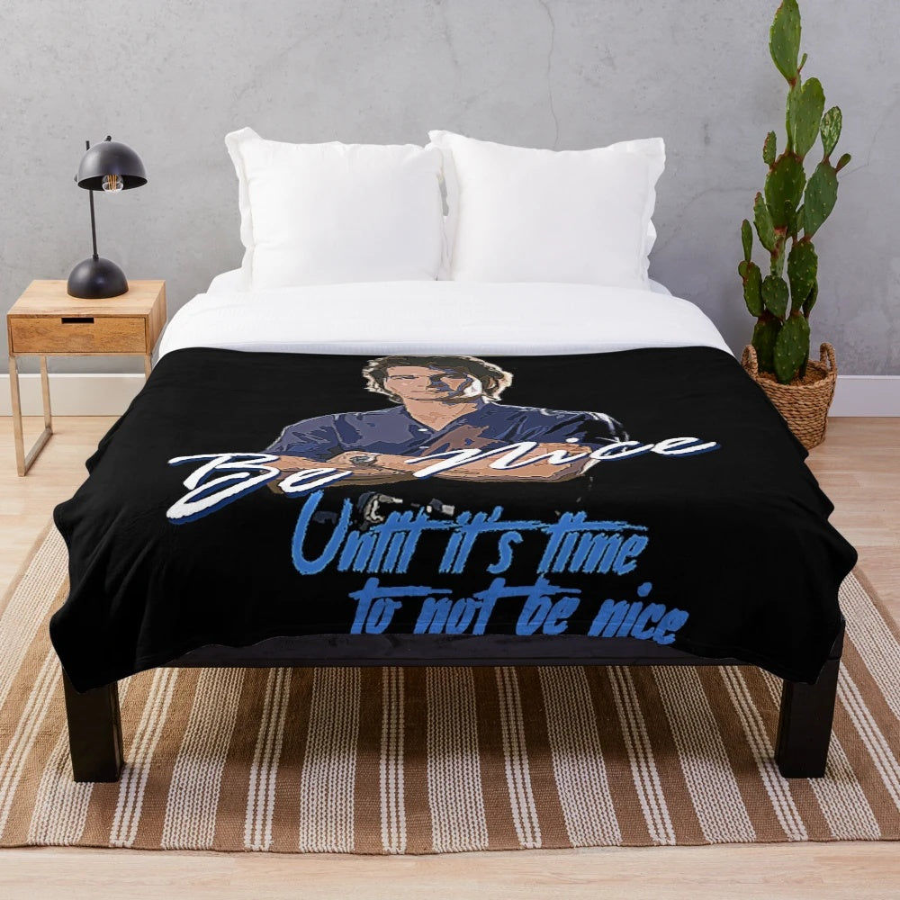 Vintage-inspired plush blanket with "Be Nice" text and 80s movie-inspired design