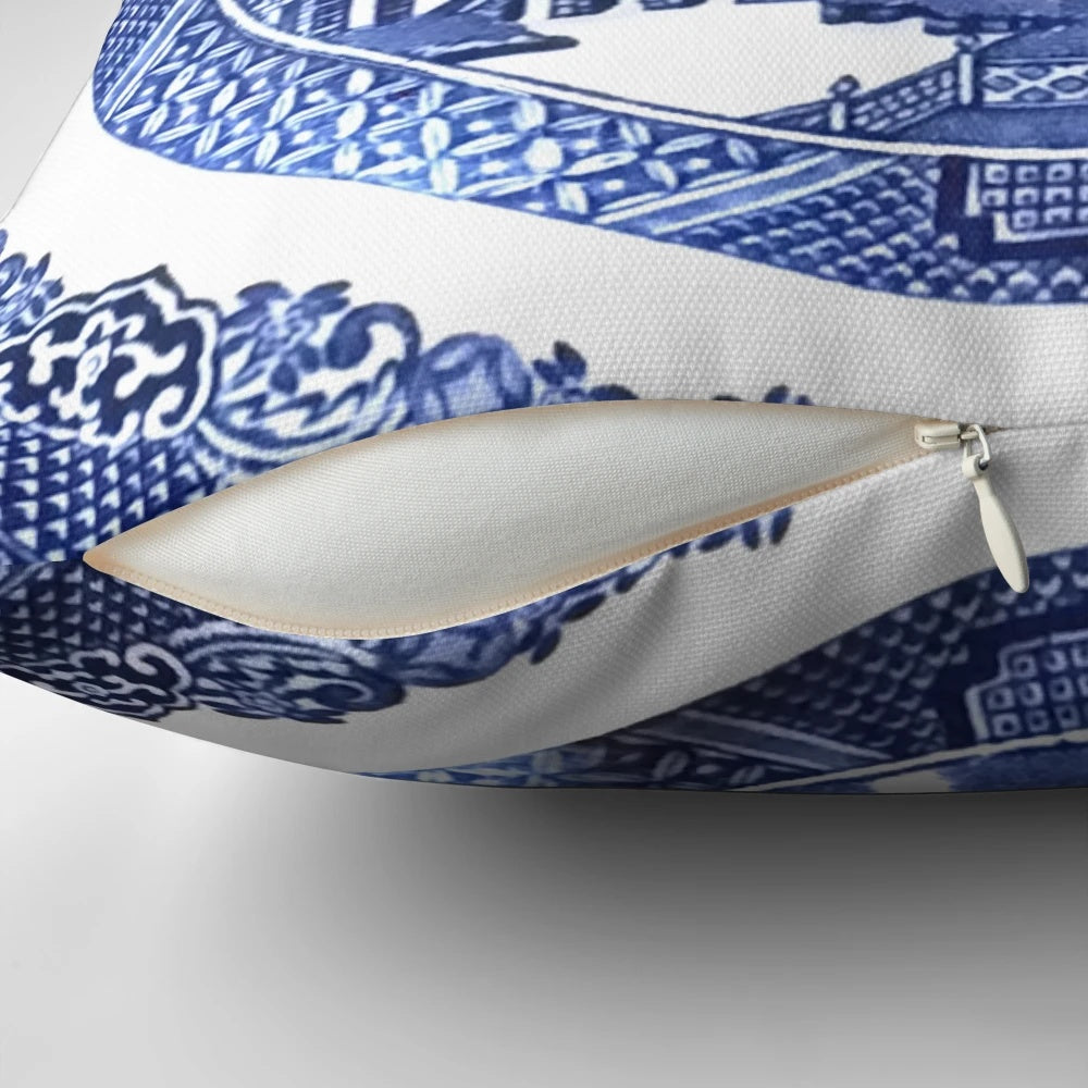 Vintage-inspired blue and white porcelain decorative pillow featuring a classic willow pattern design