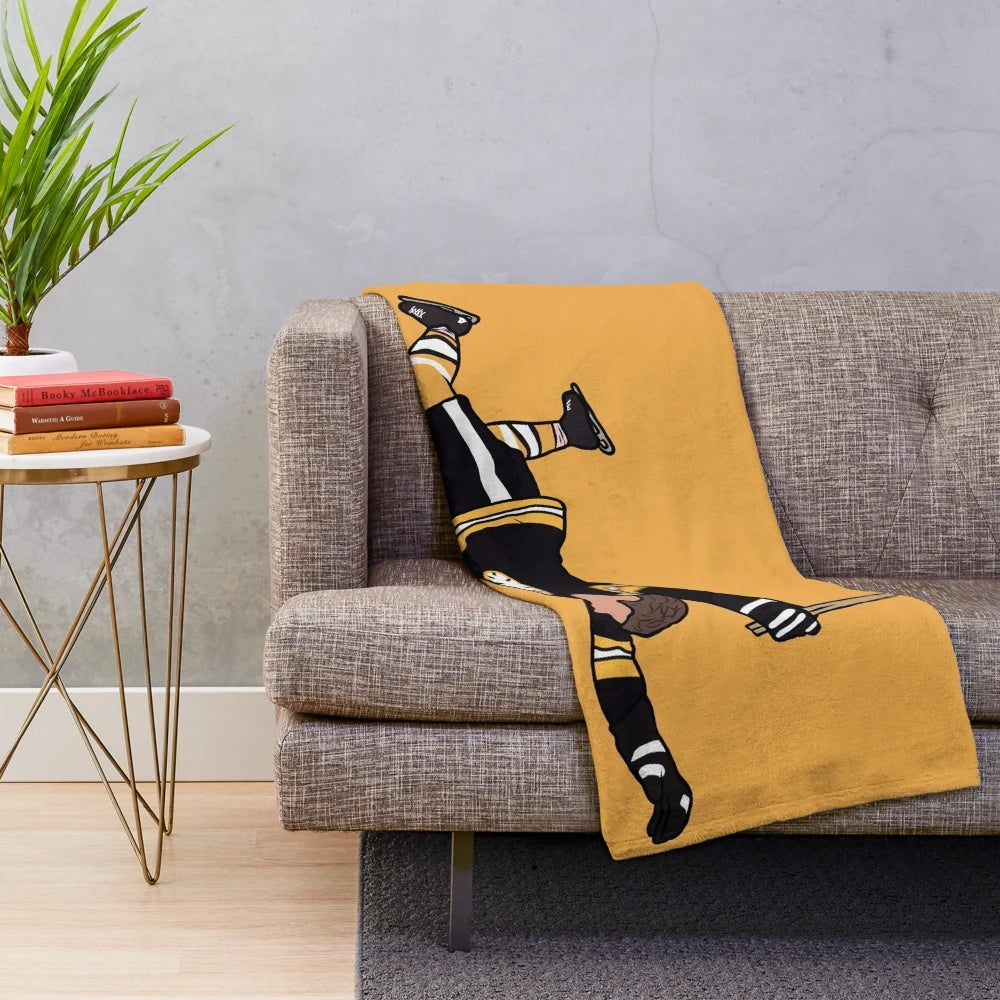 Vintage-inspired plush blanket featuring an iconic photo of Bobby Orr of the Boston Bruins celebrating a goal