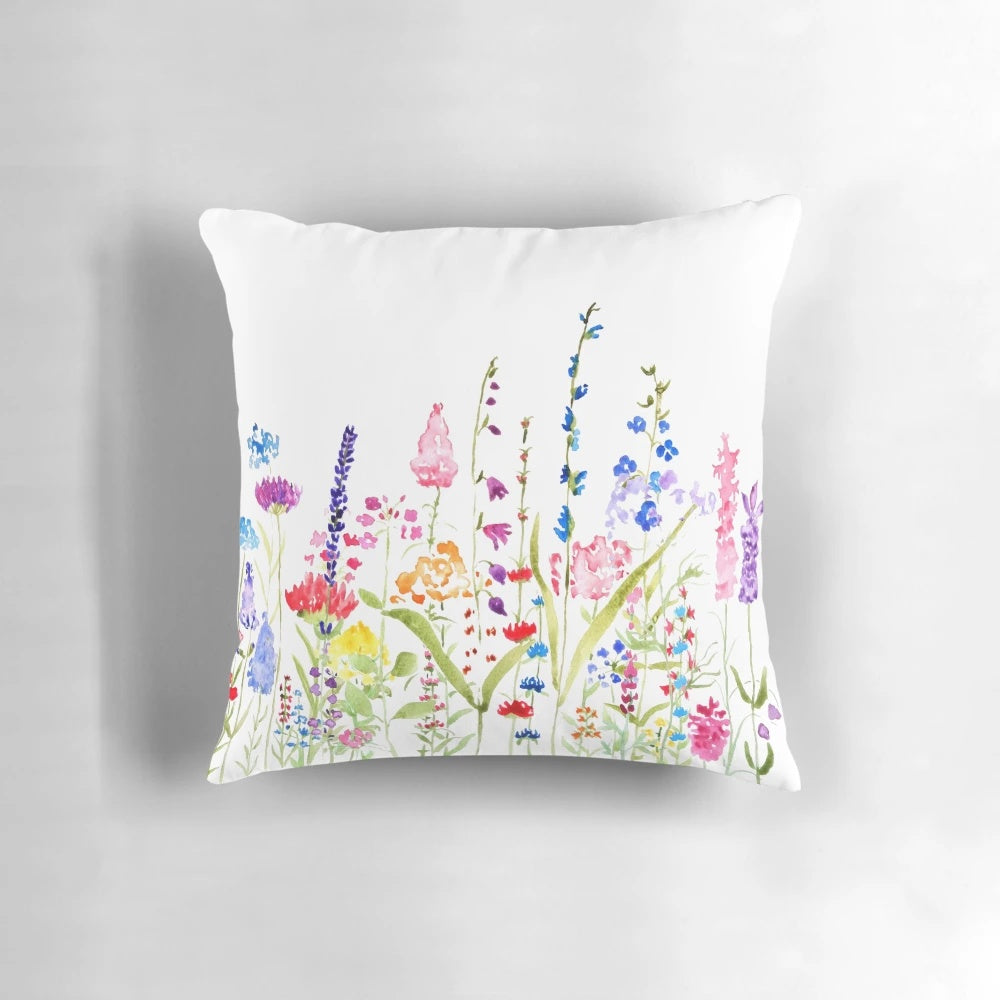 A beautifully hand-painted pillow featuring a vibrant field of colorful wild flowers, perfect for adding a touch of natural charm to any space.