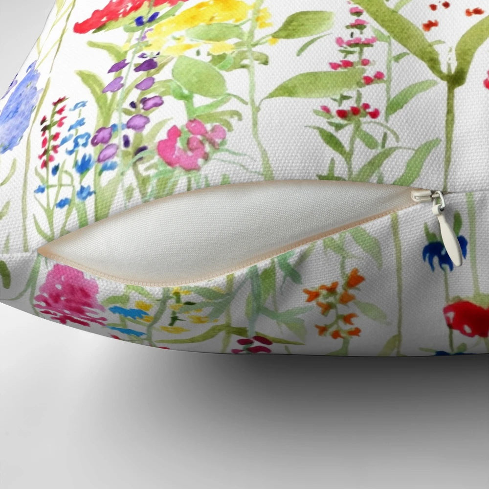 A beautifully hand-painted pillow featuring a vibrant field of colorful wild flowers, perfect for adding a touch of natural charm to any space.
