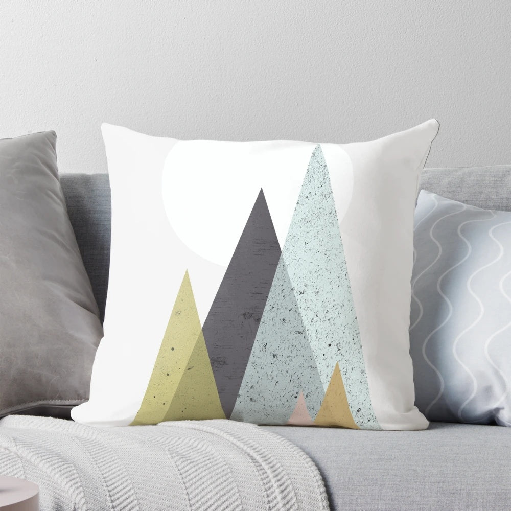 Mid-century style pillow with a geometric mountain design in a scandinavian color palette