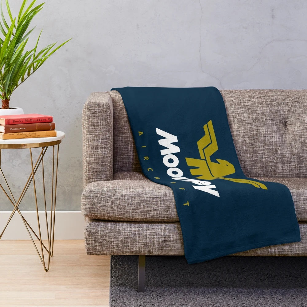 Soft and cozy plush blanket featuring a classic Mooney aircraft logo