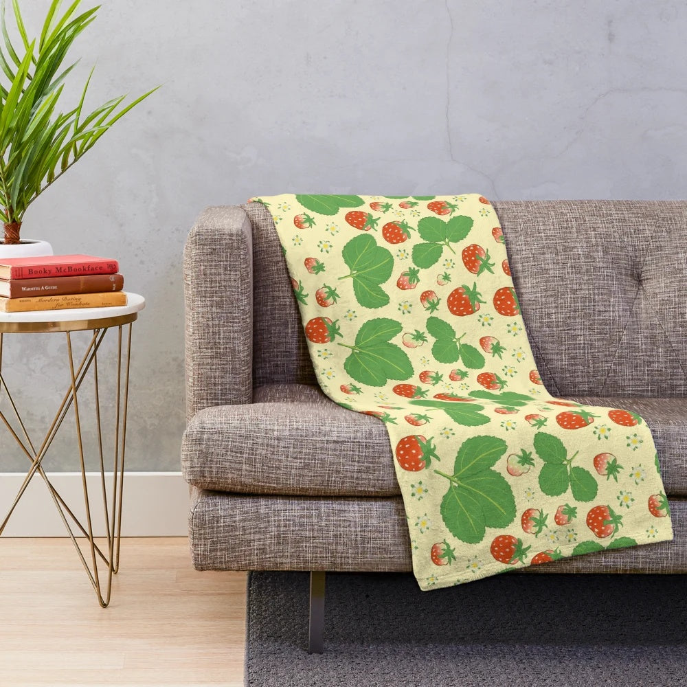 Vintage-inspired plush blanket with a repeating strawberry and floral pattern