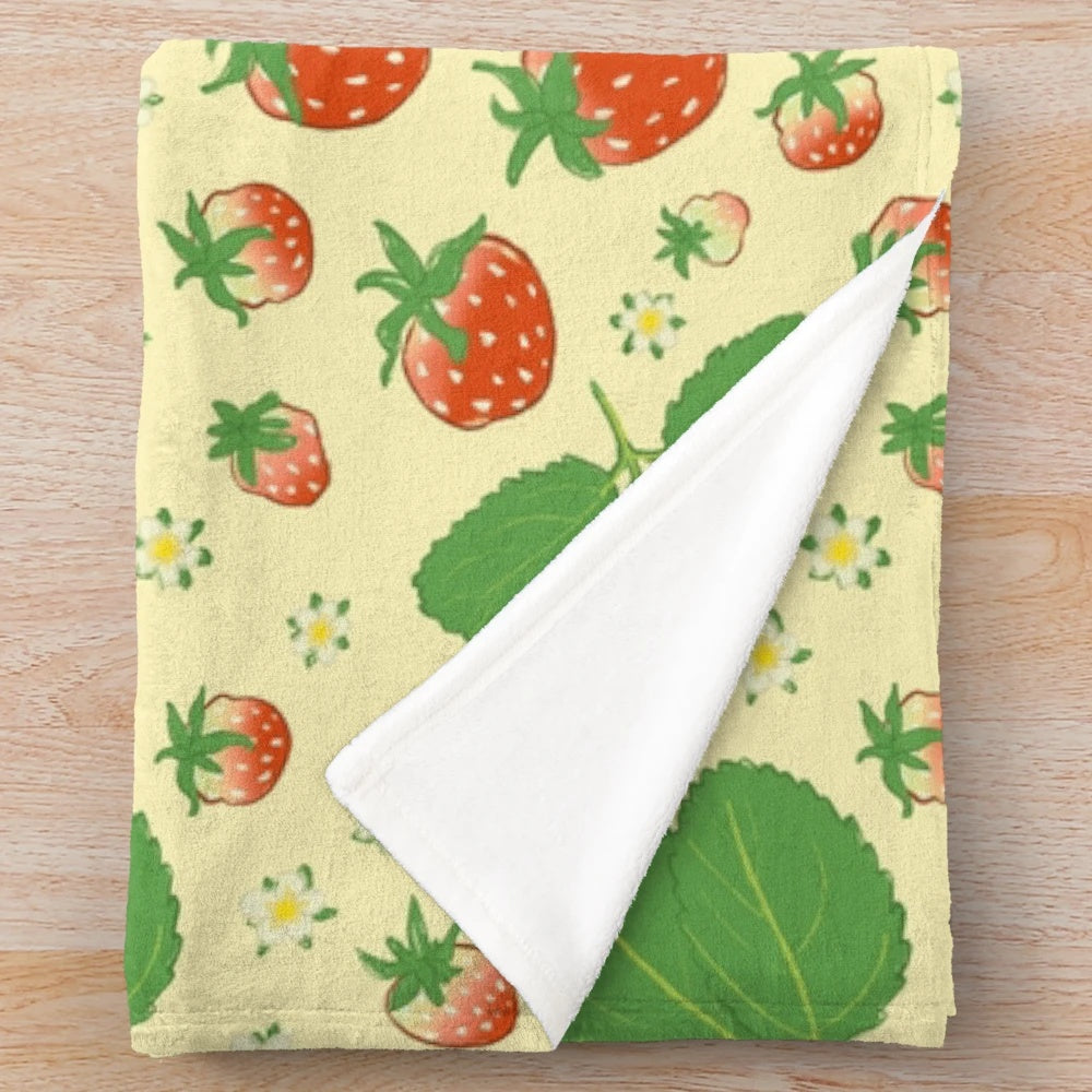 Vintage-inspired plush blanket with a repeating strawberry and floral pattern