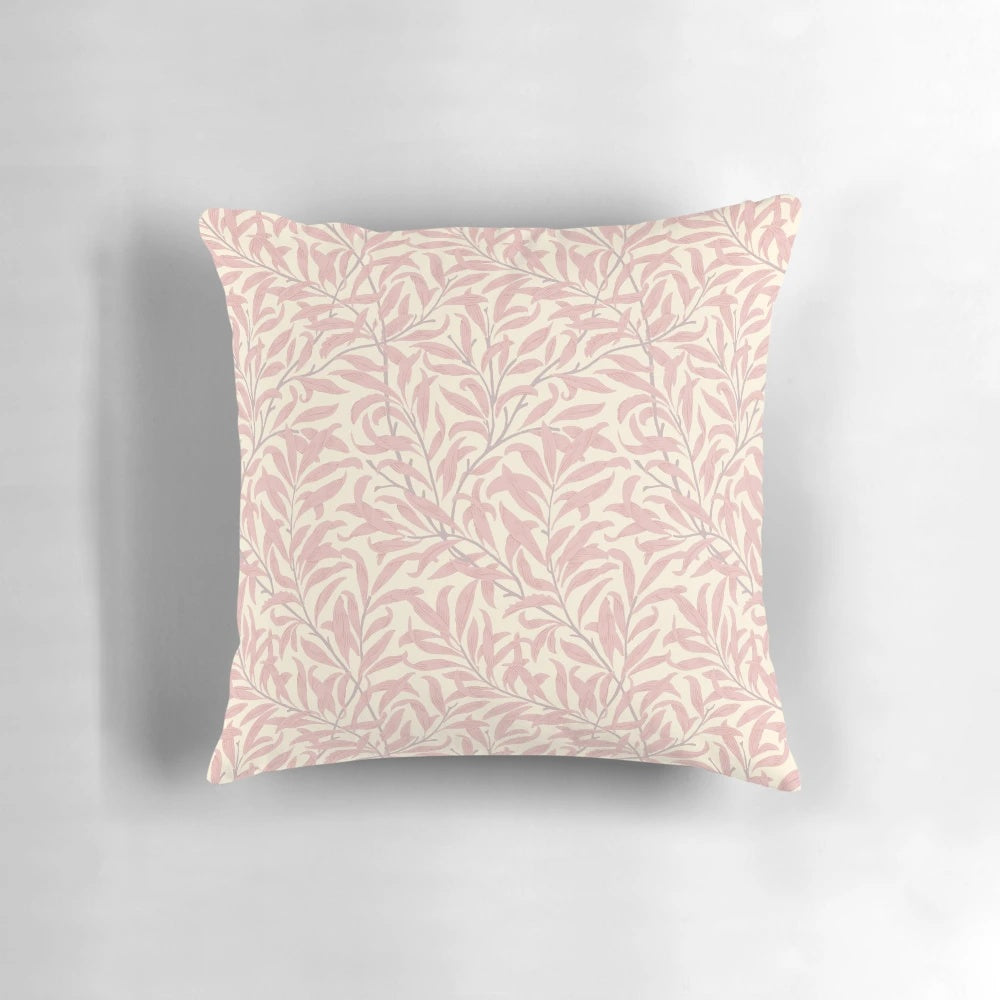 A pink and cream colored throw pillow featuring a vintage-inspired willow bough and leaf pattern, based on the textile designs of William Morris.