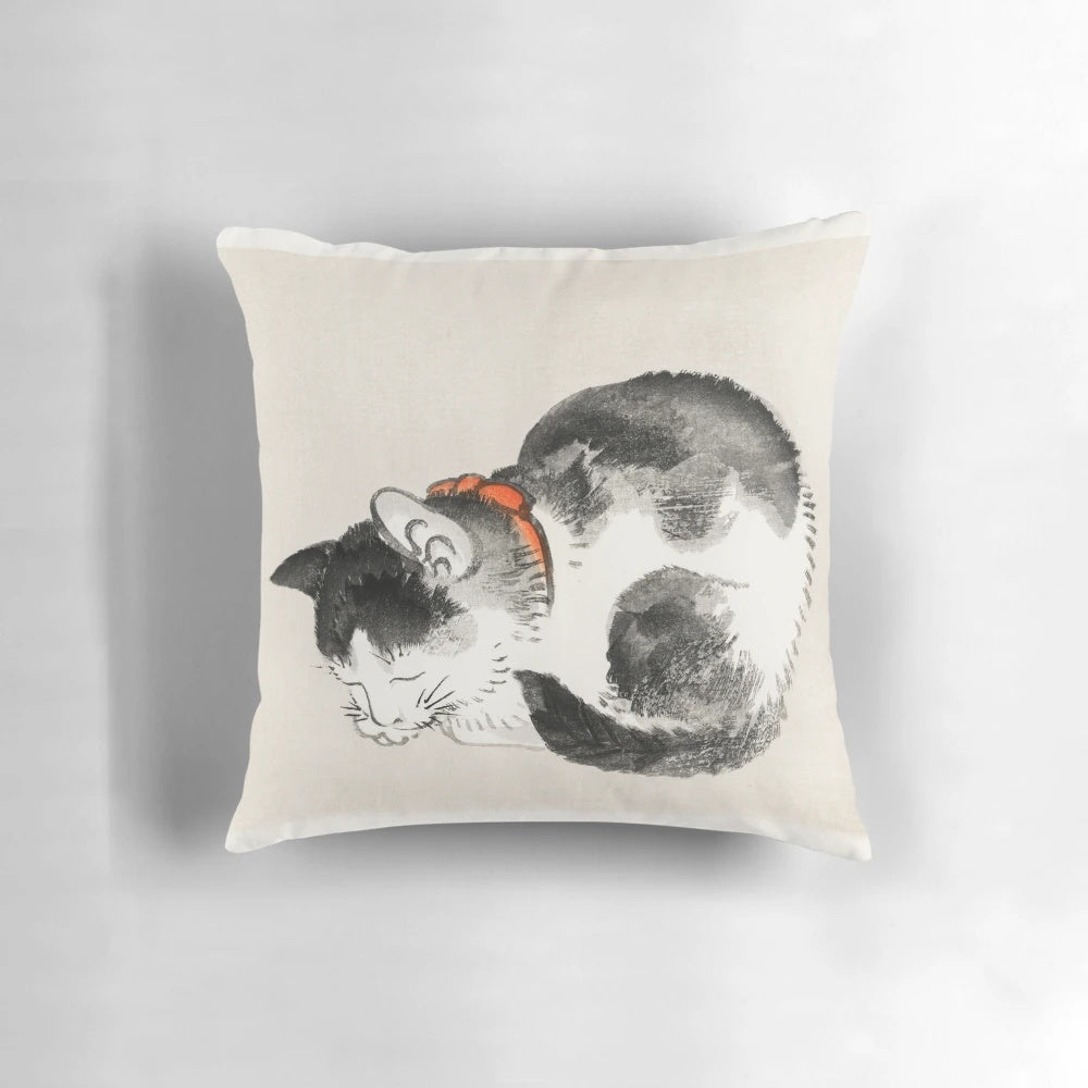 A vintage-style Japanese print of a sleeping cat on a decorative pillow.