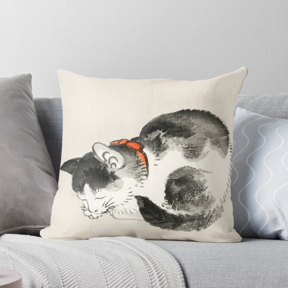 A vintage-style Japanese print of a sleeping cat on a decorative pillow.