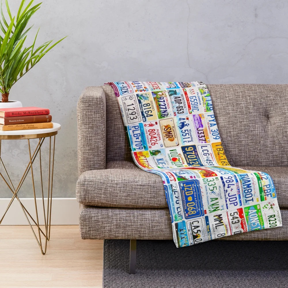 Vintage license plate wall hanging displaying a collection of colorful, weathered number plates