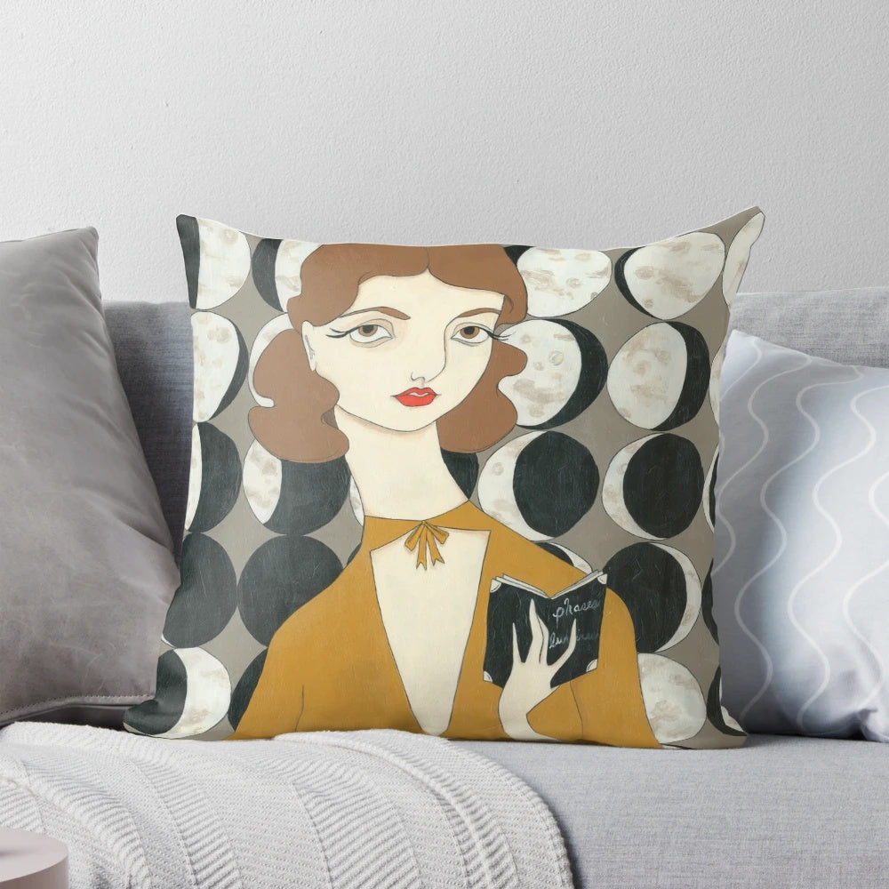 A decorative throw pillow featuring a vintage-inspired illustration of a woman's face with different moon phases in the background.