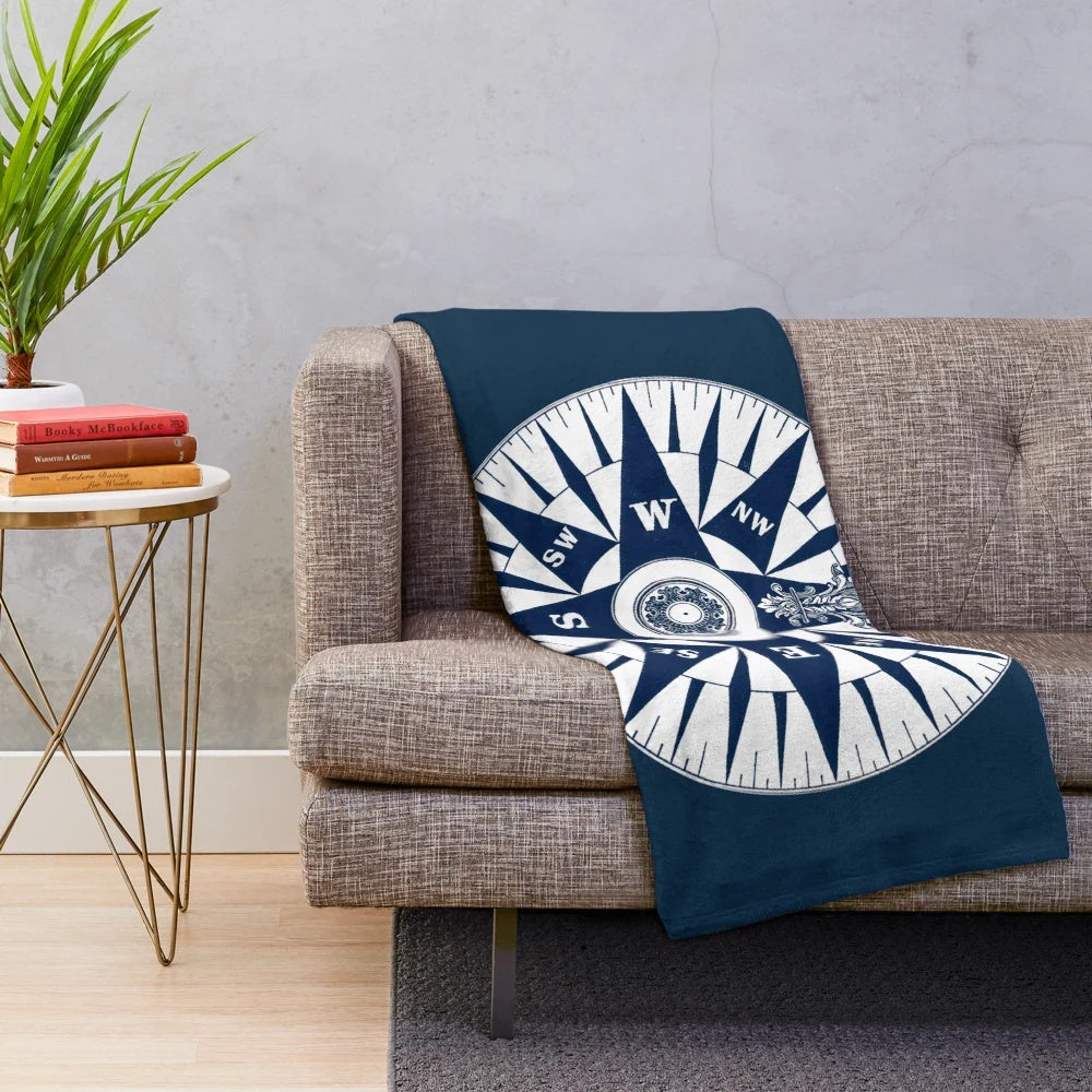 Ornate vintage nautical compass design on a navy blue plush blanket