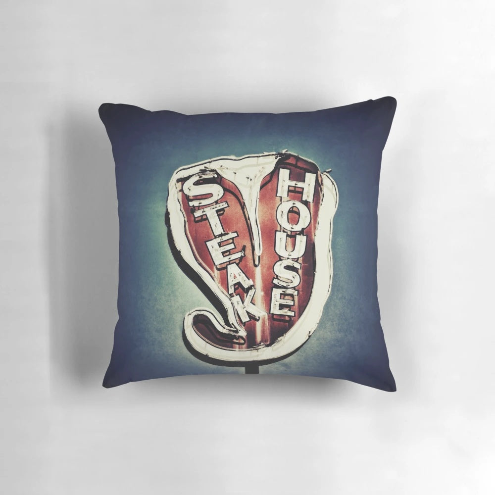 Vintage neon steakhouse sign art print in retro color photography style on a decorative pillow