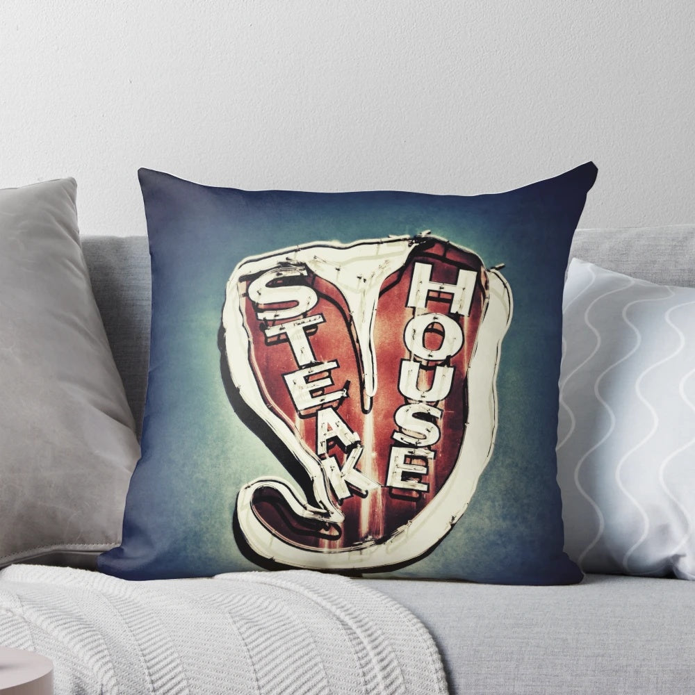 Vintage neon steakhouse sign art print in retro color photography style on a decorative pillow