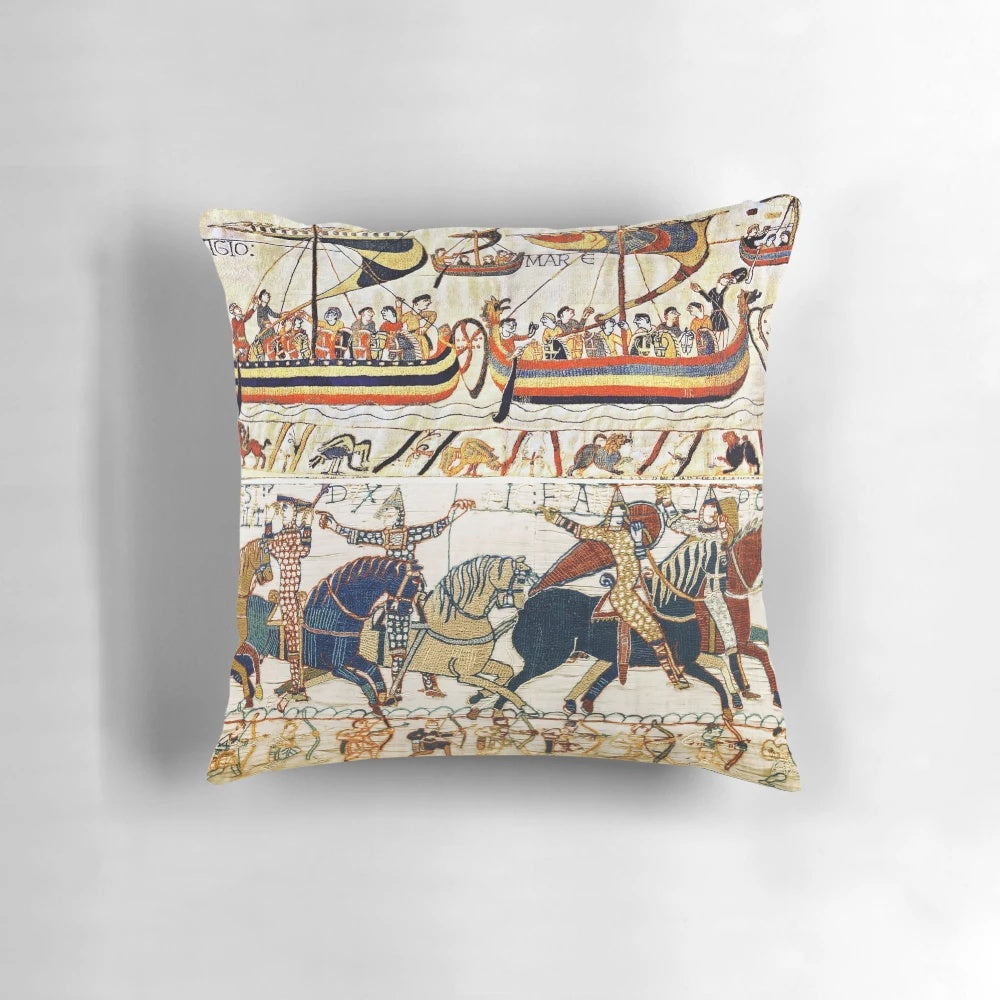 Vintage-style pillow depicting scenes from the Bayeux Tapestry, including medieval knights on horseback, archers, and Norman ships.