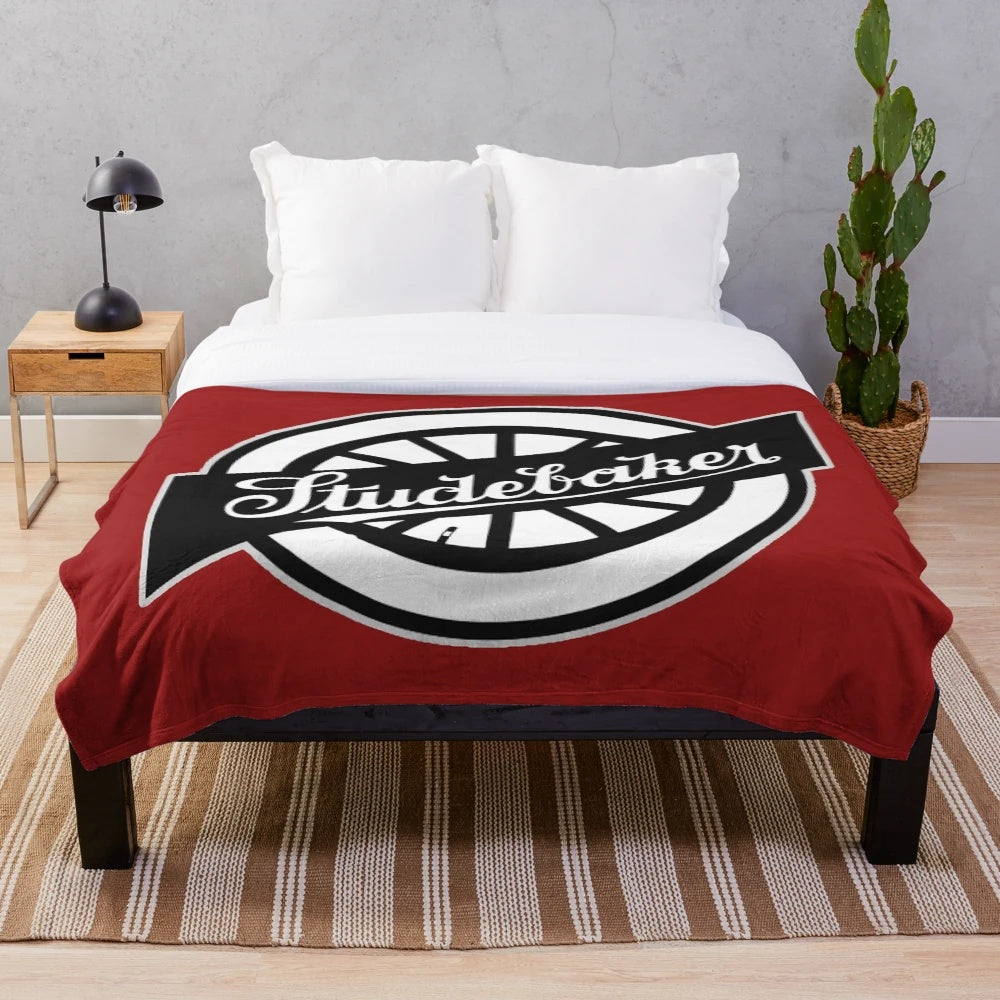 Soft and cozy plush blanket featuring the iconic Studebaker wheel logo in a retro design