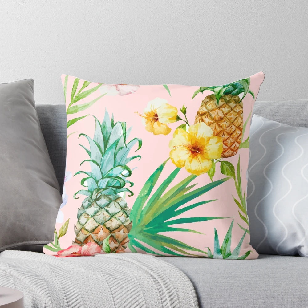 A vintage-inspired tropical botanical pillow featuring a watercolor painting of pineapples, palm leaves, and a blush color palette.
