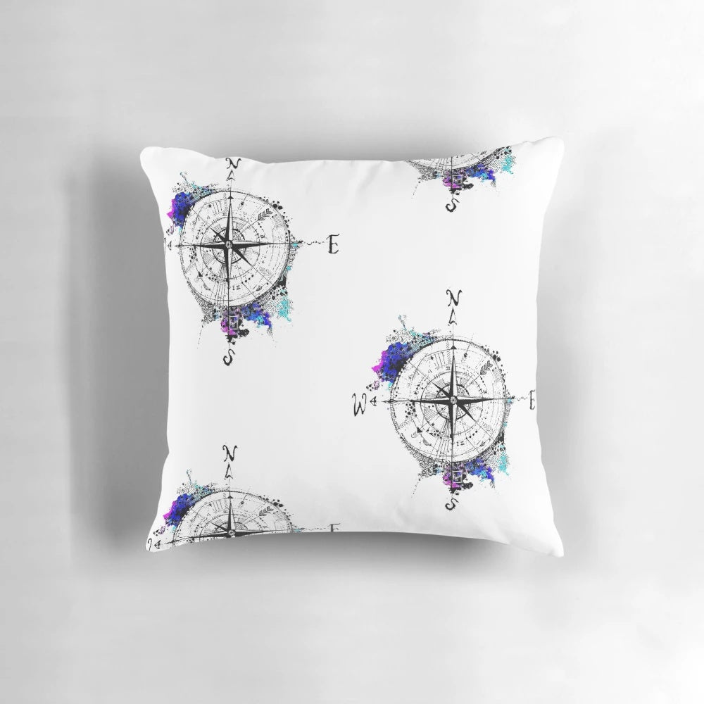 Watercolor compass design on a blue and white pillow, representing the spirit of adventure and exploration.