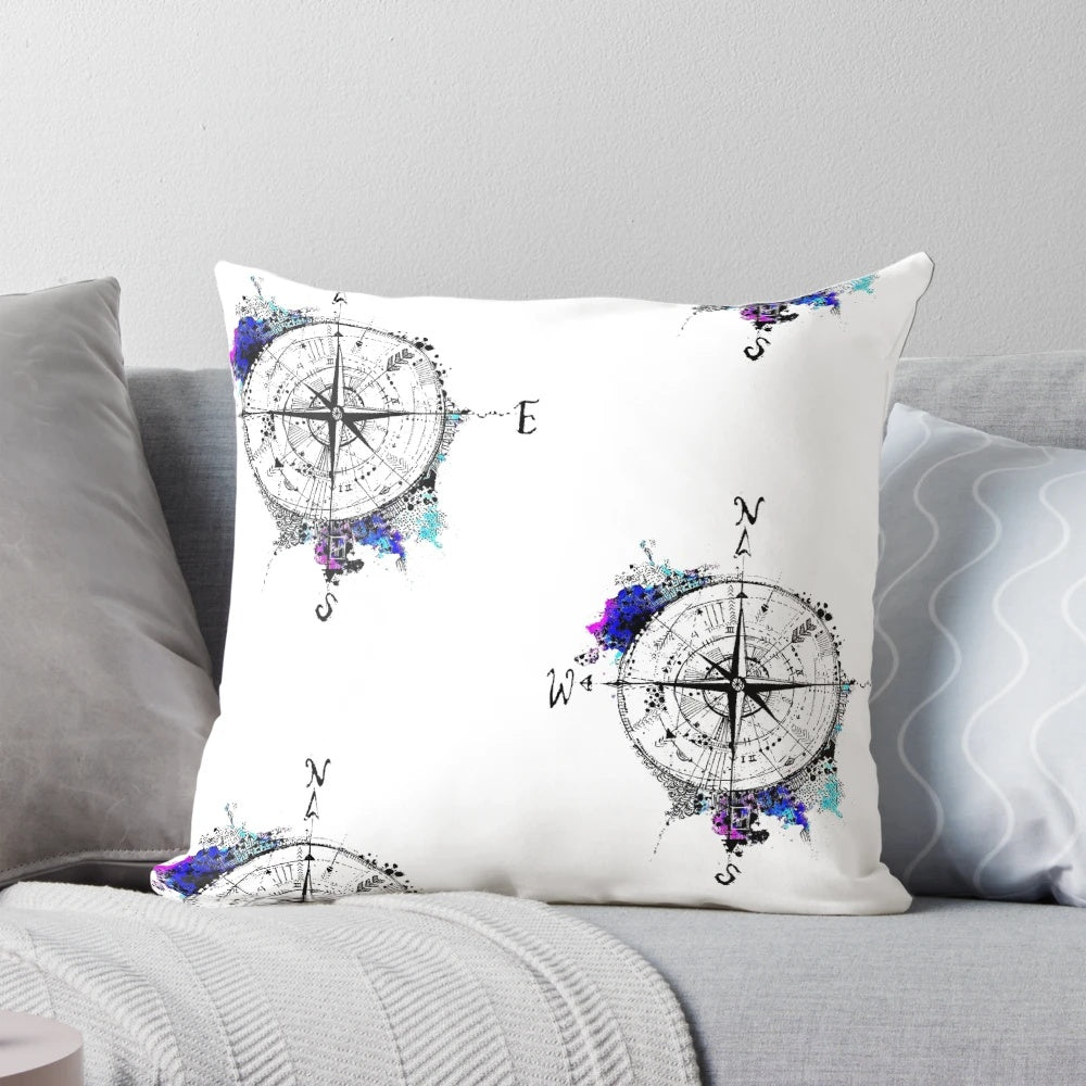 Watercolor compass design on a blue and white pillow, representing the spirit of adventure and exploration.