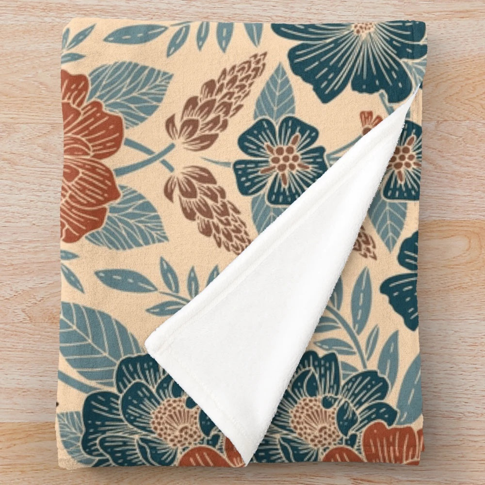 Soft and plush floral patterned blanket in shades of blue, brown, and rust