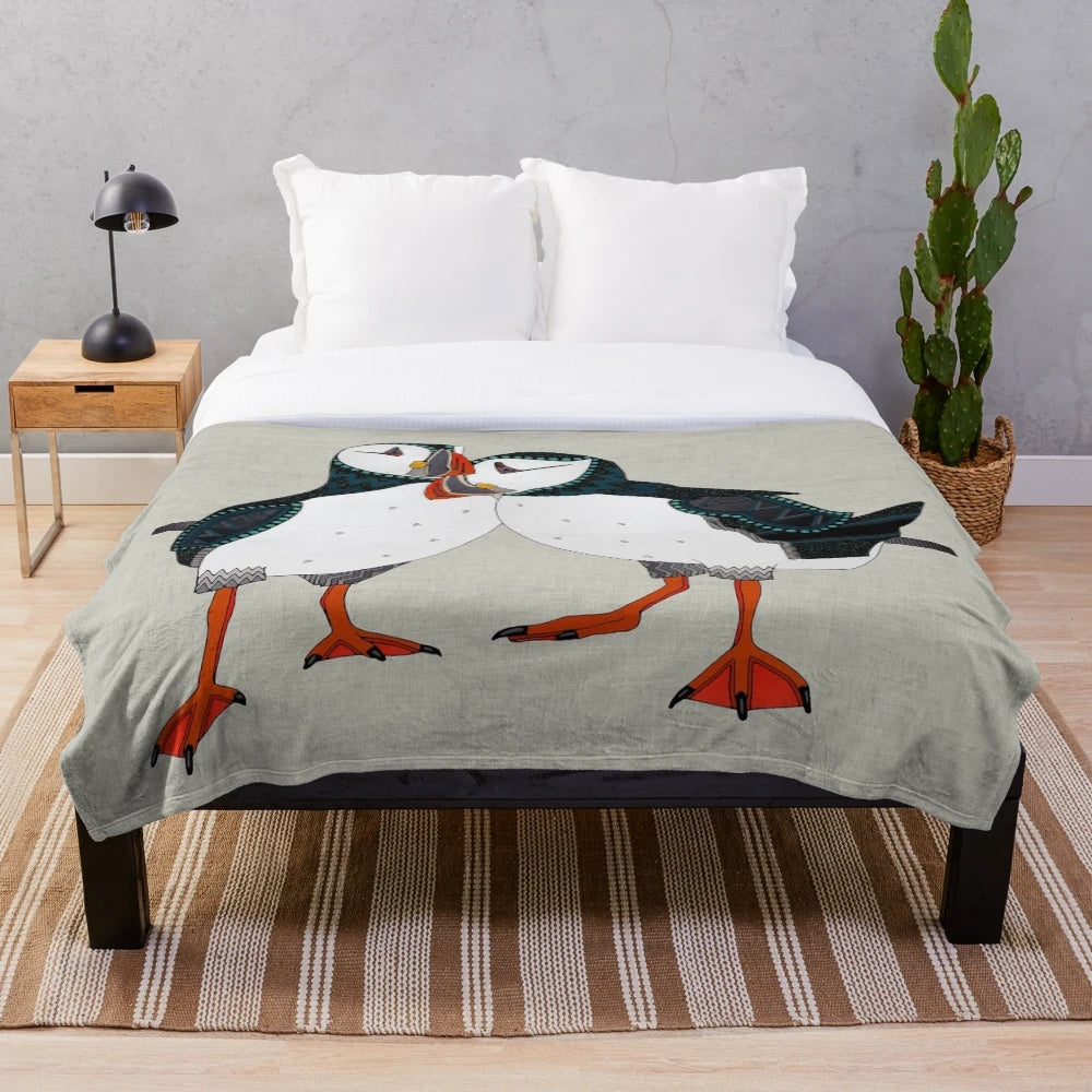 Warm grey plush blanket with a puffin bird design, perfect for nature lovers and cozy home decor.