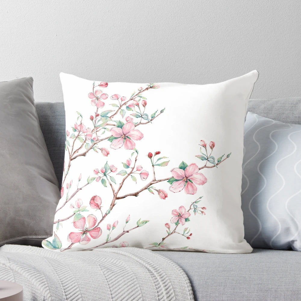 A beautifully detailed watercolor design of delicate apple blossoms in pink, white, and light blue on a decorative pillow.
