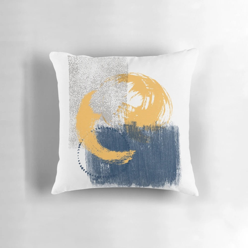 Vibrant watercolor brush stroke pattern in mustard, dark blue, and grey colors on a decorative throw pillow