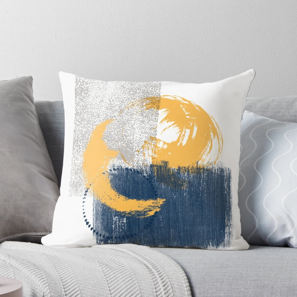 Vibrant watercolor brush stroke pattern in mustard, dark blue, and grey colors on a decorative throw pillow