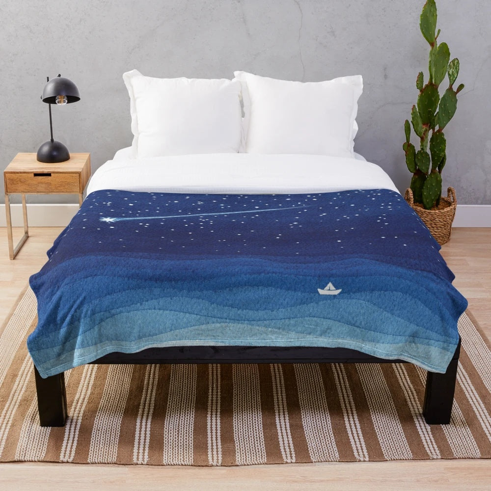 Watercolor-style plush blanket featuring a sailboat on a night sea with shooting stars