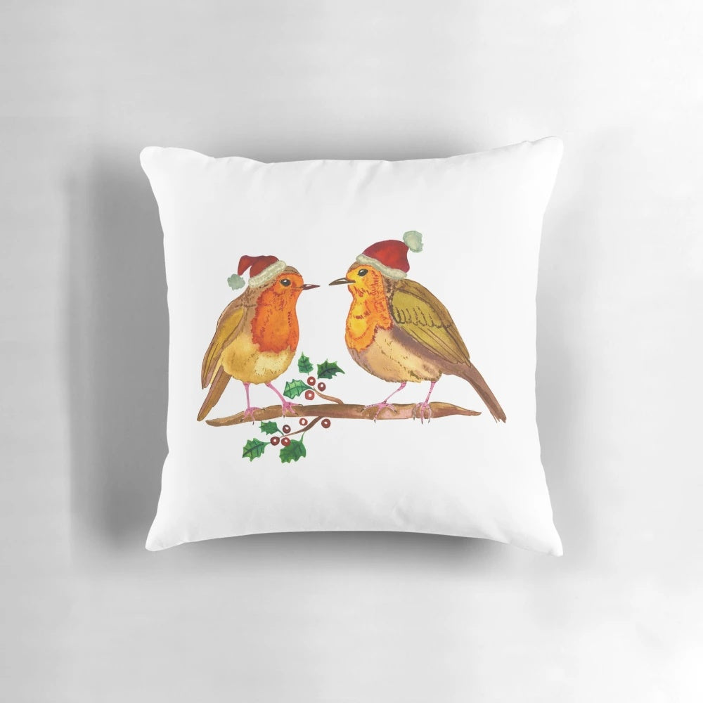 Watercolor painting of a robin bird perched on a branch, printed on a cozy throw pillow for Christmas decor.