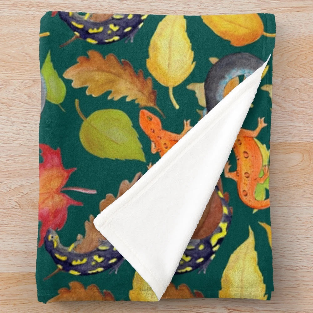 Dark green plush blanket with a watercolor pattern of salamanders and leaves