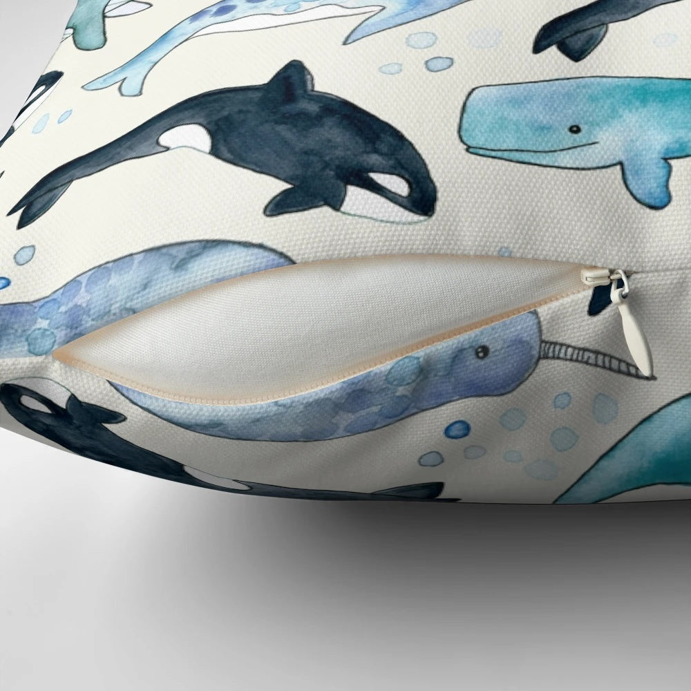 Whales, orcas, and narwhals depicted in a beautiful watercolor illustration on a plush pillow for ocean-inspired home decor.