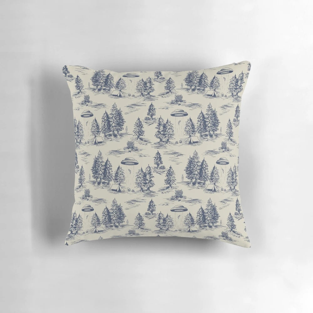 A blue pillow featuring a whimsical alien abduction-themed toile de jouy pattern.