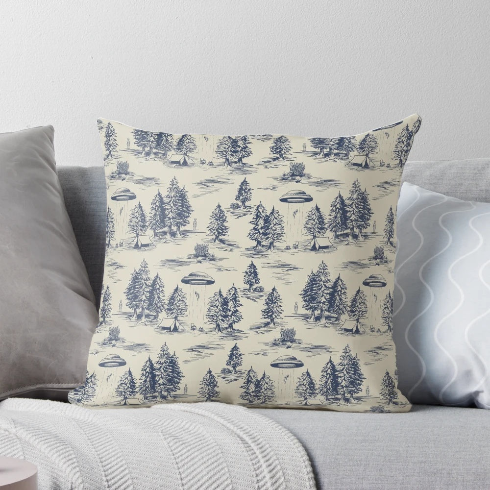 A blue pillow featuring a whimsical alien abduction-themed toile de jouy pattern.