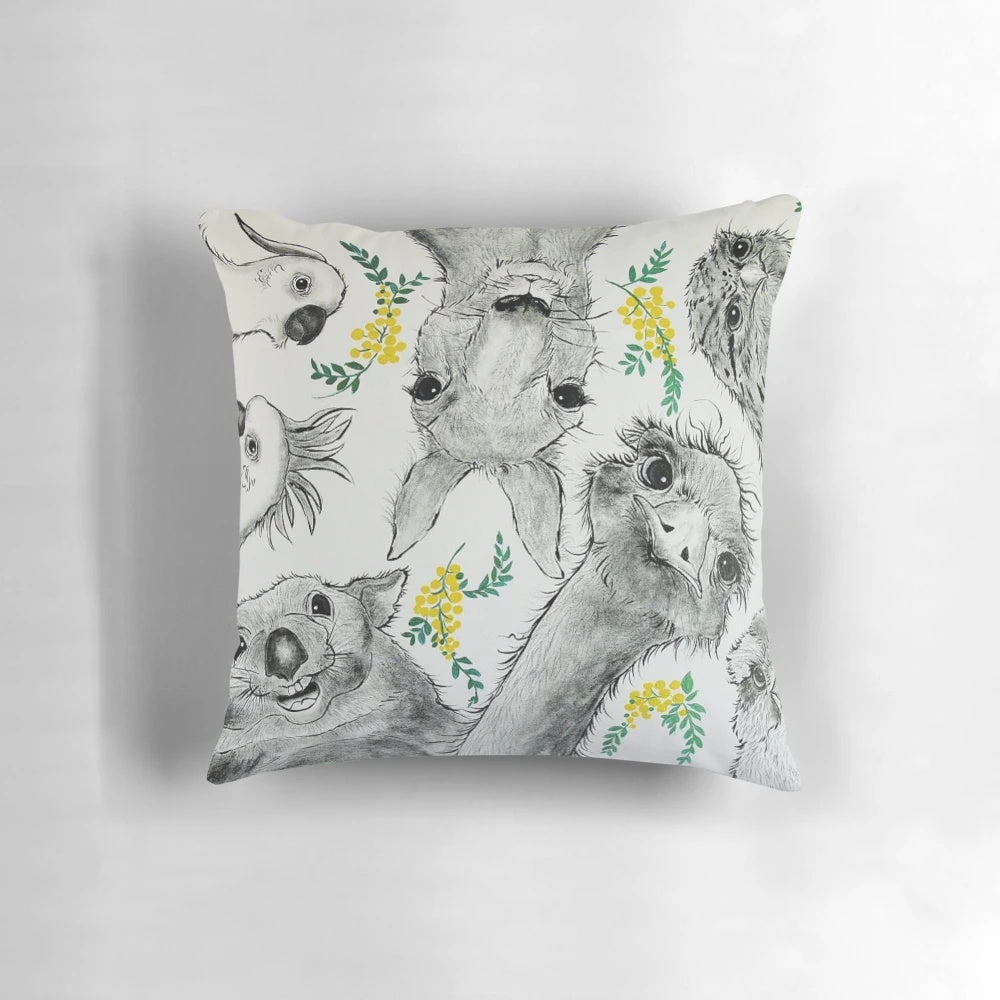 Colorful cartoon illustration of Australian native animals including a wombat, kangaroo, emu, cockatoo, and tawny frogmouth on a decorative pillow.